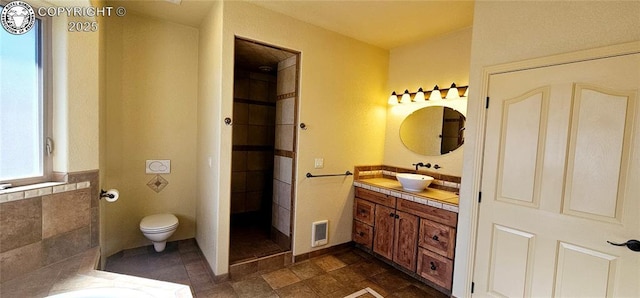 full bathroom featuring toilet, visible vents, a bath, and vanity