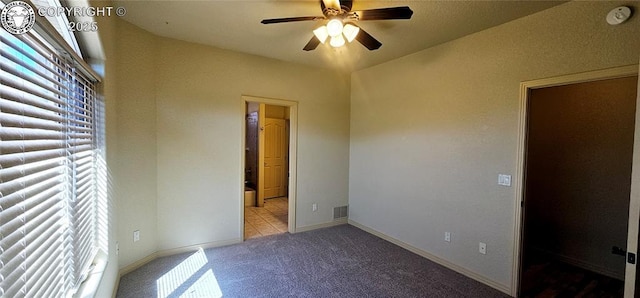 unfurnished bedroom featuring carpet floors, multiple windows, visible vents, and baseboards