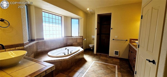 bathroom with tile patterned flooring, vanity, toilet, and a bath