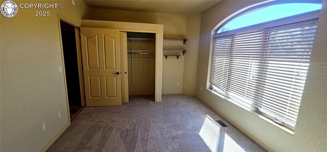 unfurnished bedroom featuring a closet, carpet flooring, visible vents, and baseboards