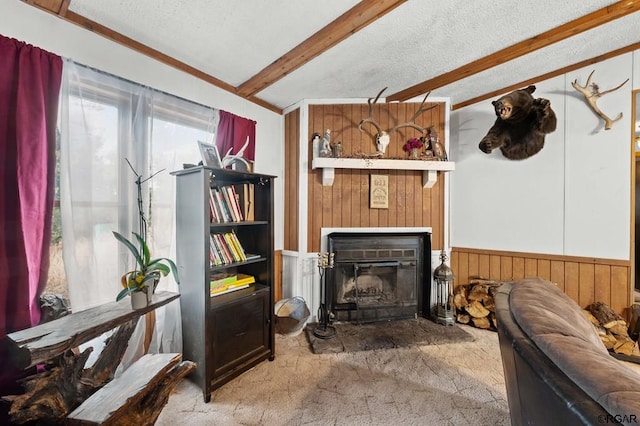 carpeted living room featuring beam ceiling, a textured ceiling, and wood walls