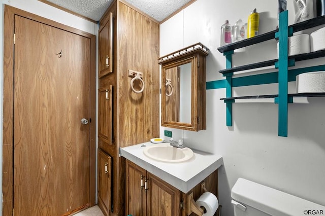 bathroom featuring vanity, toilet, and a textured ceiling