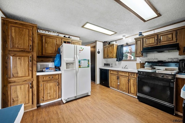 kitchen with white appliances, sink, a textured ceiling, and light hardwood / wood-style flooring