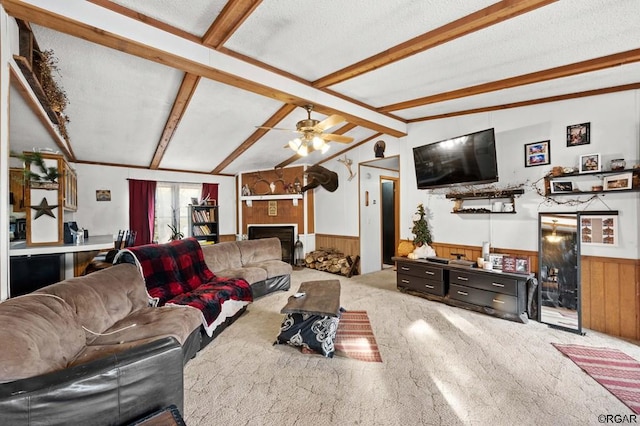 living room featuring wood walls, vaulted ceiling with beams, light colored carpet, ceiling fan, and a textured ceiling