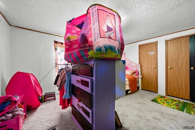 game room featuring ornamental molding, a textured ceiling, and carpet