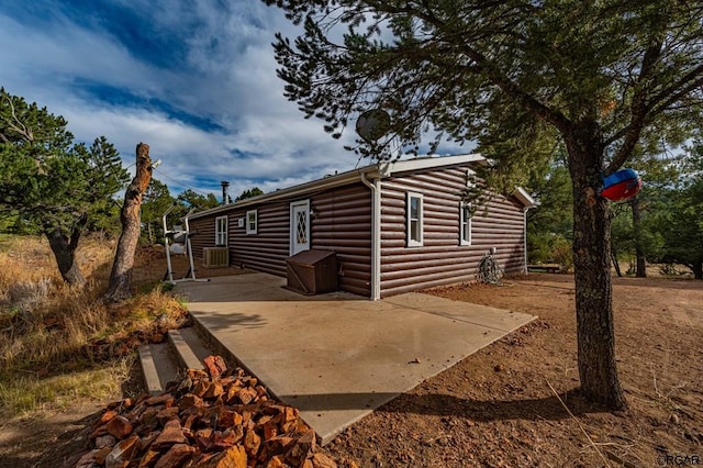 view of side of home featuring cooling unit and a patio area