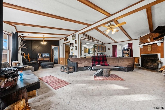 living room with lofted ceiling with beams, carpet, and ceiling fan