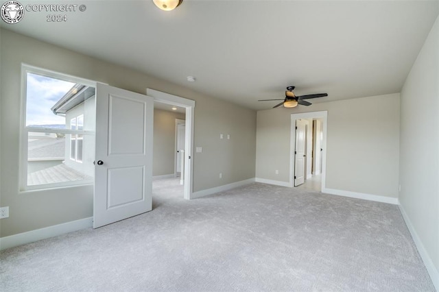 unfurnished room with ceiling fan and light colored carpet