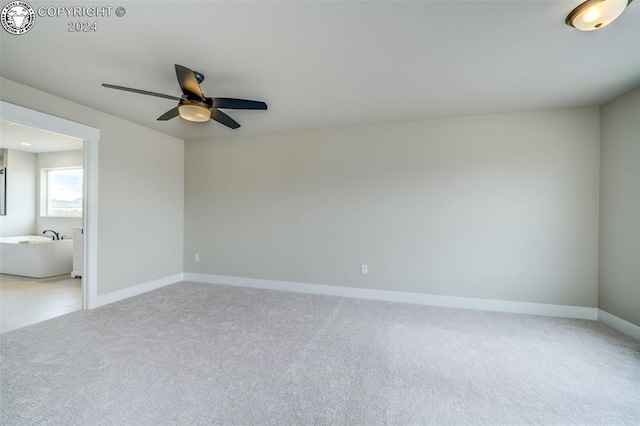 carpeted spare room featuring ceiling fan