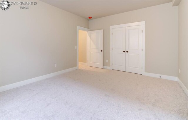 unfurnished bedroom with carpet flooring and a closet