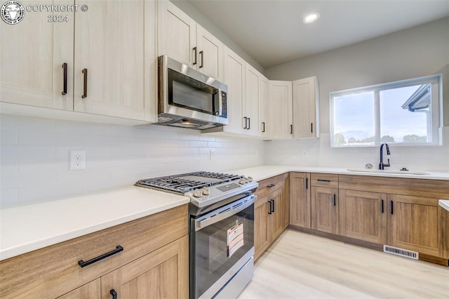 kitchen featuring white cabinetry, appliances with stainless steel finishes, sink, and backsplash