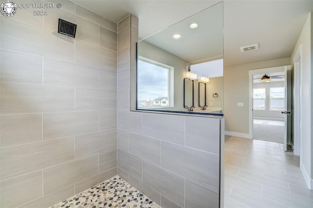 bathroom featuring vanity, ceiling fan, a healthy amount of sunlight, and walk in shower