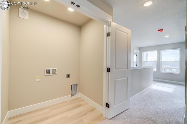 laundry area with hookup for an electric dryer, light hardwood / wood-style floors, and hookup for a washing machine