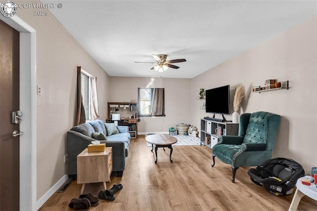 living room featuring ceiling fan and hardwood / wood-style floors