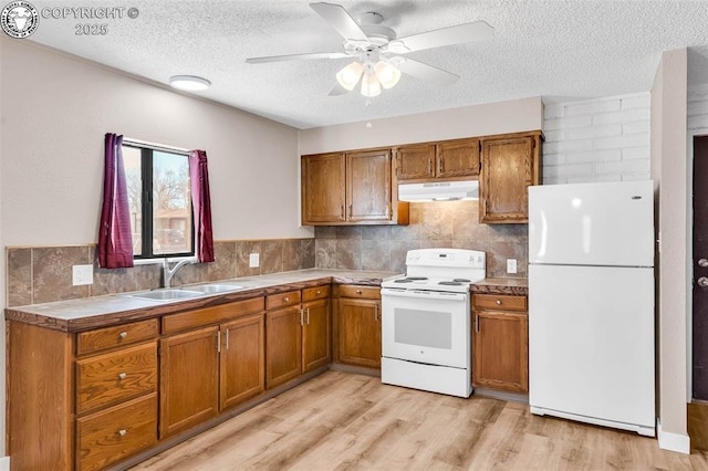 kitchen with sink, white appliances, light hardwood / wood-style flooring, a textured ceiling, and ceiling fan