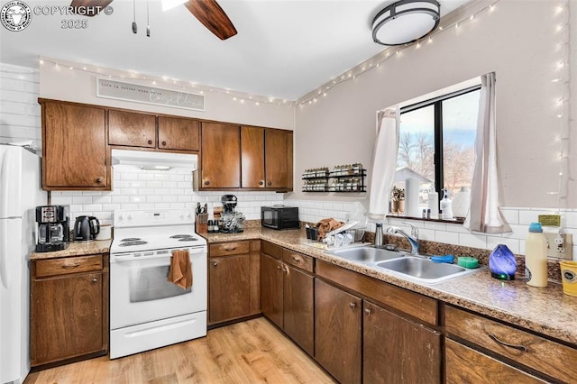 kitchen with sink, tasteful backsplash, light wood-type flooring, ceiling fan, and white appliances