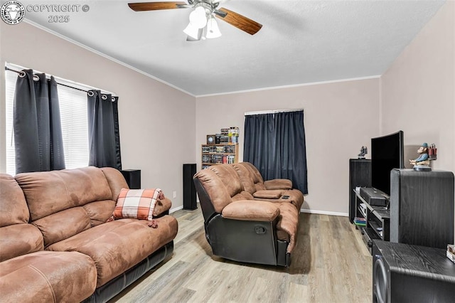 living room with ornamental molding, light hardwood / wood-style floors, and ceiling fan