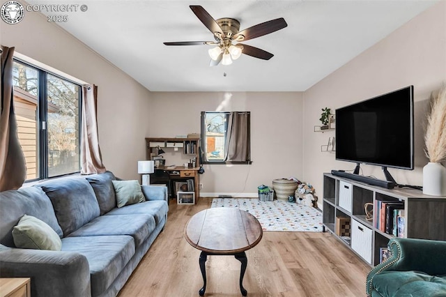 living room with ceiling fan and light wood-type flooring