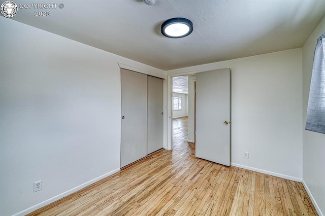 unfurnished bedroom featuring light wood-type flooring and a closet