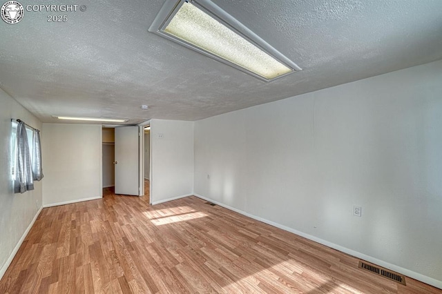 empty room featuring light hardwood / wood-style flooring and a textured ceiling