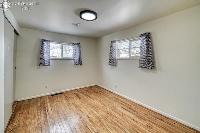 unfurnished bedroom featuring light hardwood / wood-style floors and multiple windows