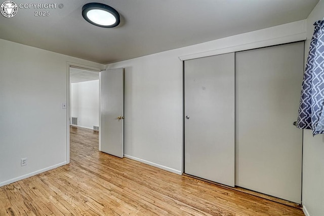 unfurnished bedroom with a closet and light hardwood / wood-style flooring