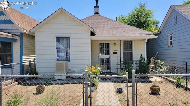 1318 Spruce St, Pueblo, CO 81004 - view of front of house featuring a gate, a fenced front yard, a shingled roof, a chimney, and covered porch