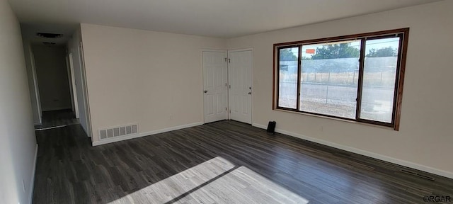 unfurnished room featuring dark wood-type flooring