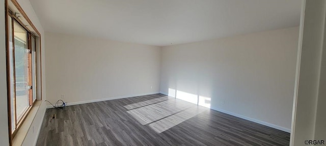 unfurnished room with dark hardwood / wood-style flooring