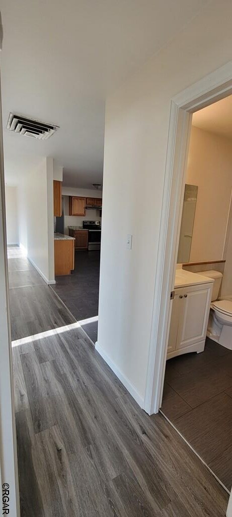 hallway with dark hardwood / wood-style flooring