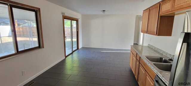 kitchen featuring light stone counters, sink, and dishwasher