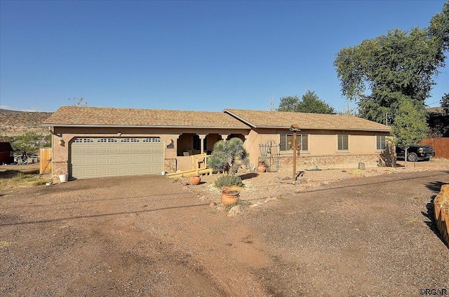 ranch-style house featuring an attached garage, stucco siding, and concrete driveway