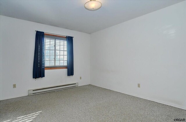 carpeted spare room featuring a baseboard heating unit