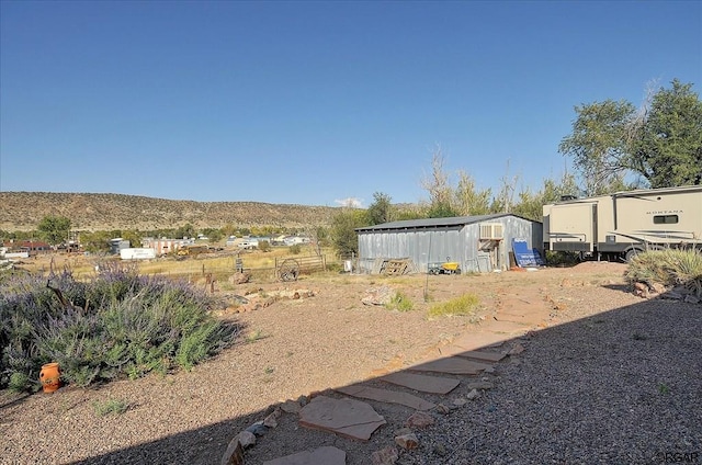 view of yard featuring an outdoor structure and a mountain view