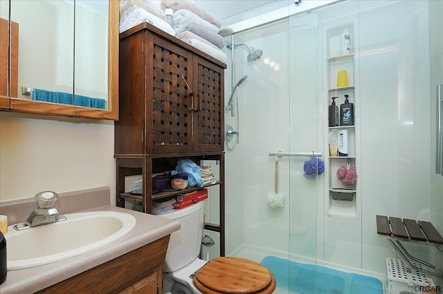 bathroom with walk in shower, vanity, and toilet