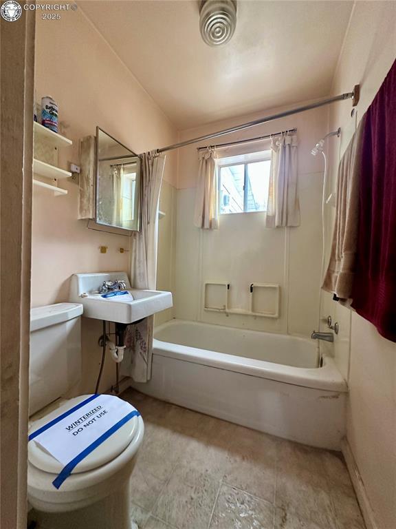 full bathroom featuring sink, toilet, and shower / bath combo with shower curtain