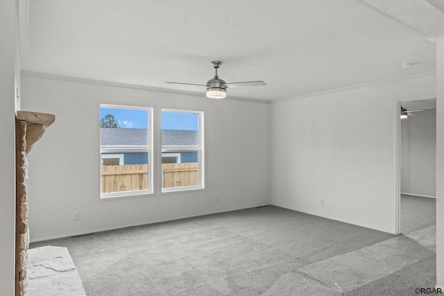 empty room featuring crown molding, light colored carpet, and ceiling fan