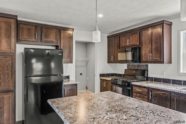 kitchen featuring pendant lighting, ornamental molding, dark brown cabinets, and black appliances