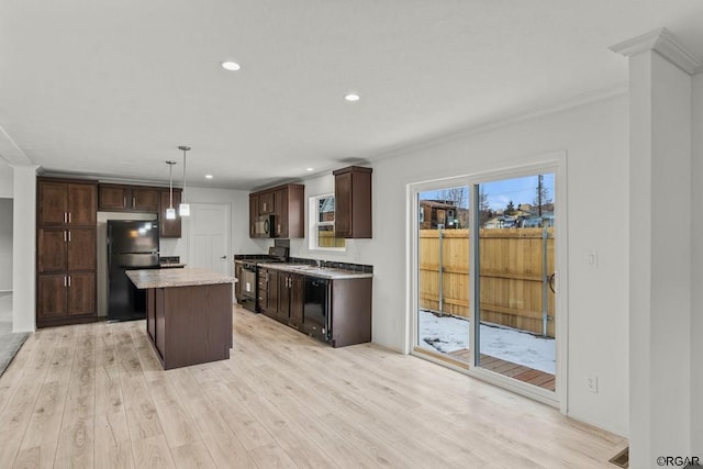 kitchen featuring hanging light fixtures, a center island, light hardwood / wood-style floors, and black appliances