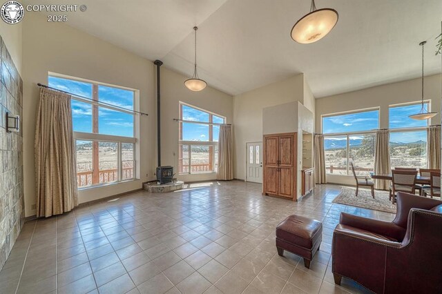750 Roundup Rd, Westcliffe, CO 81252 - living room featuring light tile patterned flooring, a high ceiling, and a wood stove