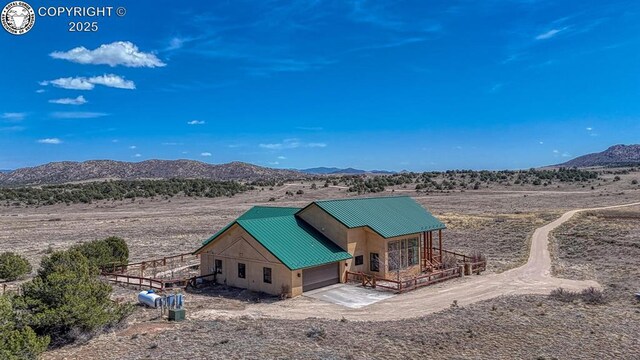 750 Roundup Rd, Westcliffe, CO 81252 - back of property featuring a mountain view, view of desert, metal roof, and a garage