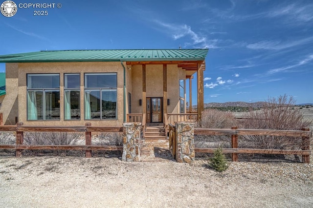 750 Roundup Rd, Westcliffe, CO 81252 - view of front facade with metal roof, stucco siding, and fence
