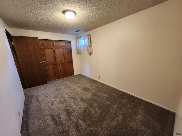 unfurnished bedroom with a closet, a textured ceiling, and carpet flooring