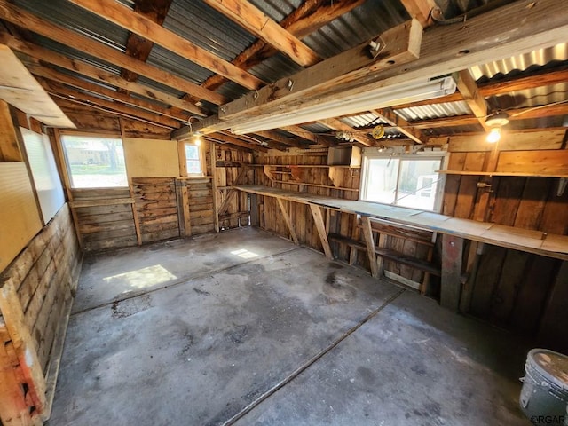 interior space with a wealth of natural light, concrete floors, and wooden walls