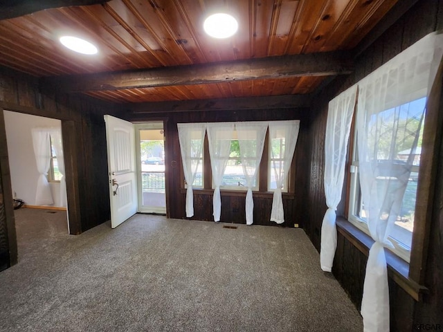 spare room featuring beamed ceiling, carpet flooring, and wooden ceiling