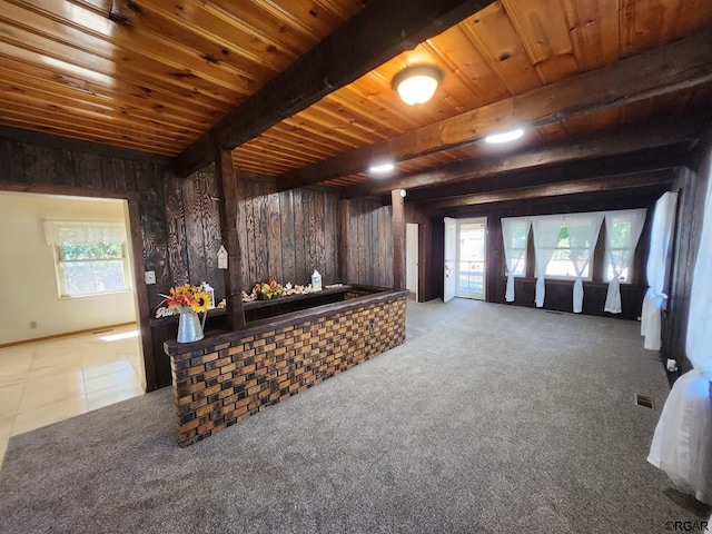 carpeted living room featuring wood ceiling, beam ceiling, and wooden walls