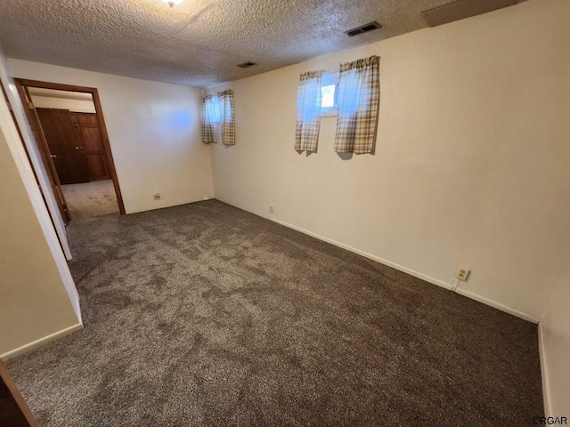 carpeted spare room with a textured ceiling