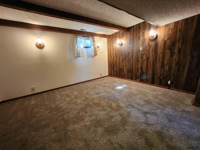 basement featuring carpet, wooden walls, and a textured ceiling