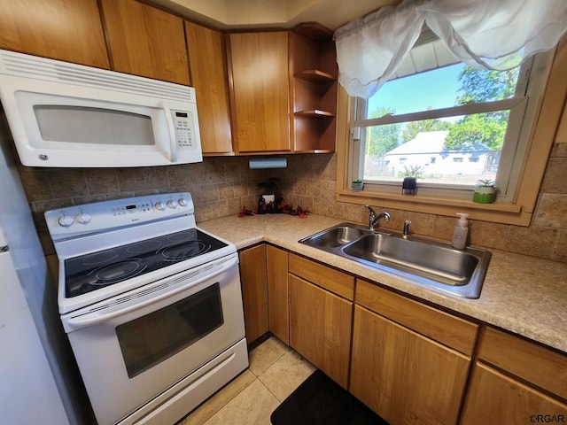 kitchen with tasteful backsplash, sink, white appliances, and light tile patterned floors