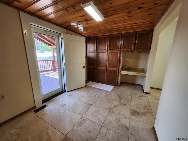 doorway to outside featuring wood ceiling and light tile patterned flooring